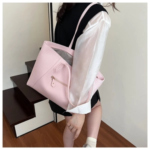 Close-up of a light pink tote bag featuring lychee grain texture and front zipper pocket