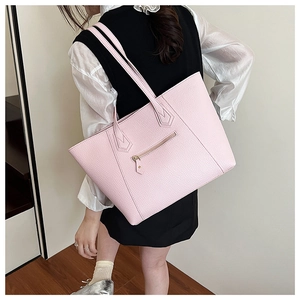 Detailed close-up of pink tote bag with lychee texture and front zipper pocket