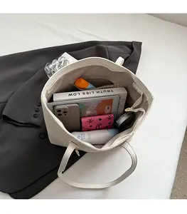 Interior view of the cream tote bag showing large capacity for tablet and cosmetics