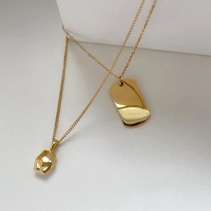 Détail du collier en titane doré avec pendentif rectangulaire et pierre de lave