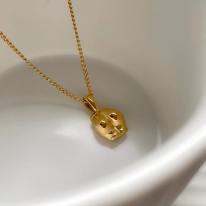 Détail macro du pendentif tête de panthère dorée polie sur porcelaine blanche