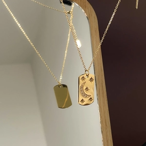 Détail macro du pendentif céleste doré avec gravure lune et étoiles et cristaux brillants