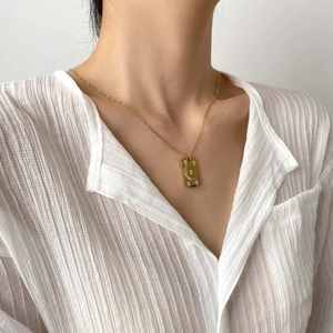 Collier vintage en acier titane doré avec pendentif lune et étoile sur mannequin en chemise