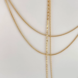 Double-layered golden snake chain necklace with shimmering sequin pendant details