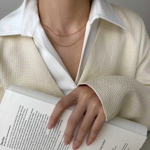 Close-up of minimalist double-layer gold snake chain necklace on model collarbone