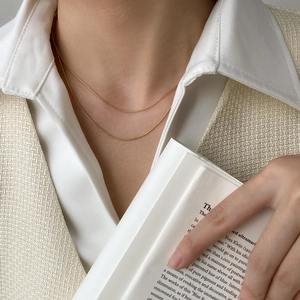 Minimalist double-layered gold snake chain necklace for women styled on a white shirt