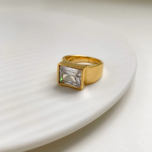 Macro view of wide 18k gold plated band featuring a large rectangular cut zircon gem