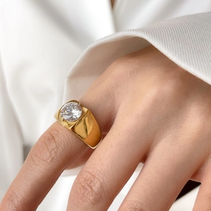 Polished 18k gold plated titanium steel ring featuring a large round cubic zirconia