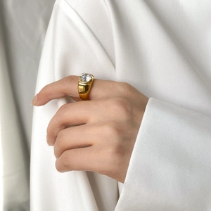 Detail of a minimalist 18k gold plated titanium ring featuring a large round zircon stone