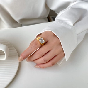 Detail of a 18k gold plated titanium ring featuring a large rectangular zircon stone