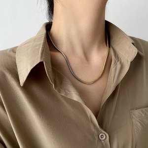 Détail du collier chaîne serpent bicolore or et argent porté pour un style professionnel