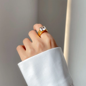 Macro detail of 18k gold plated titanium ring with large rectangular zircon stone
