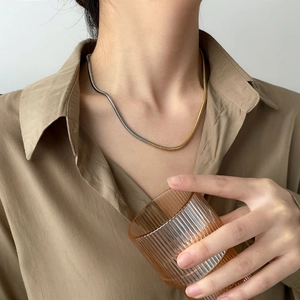 Détail du collier chaîne serpent bicolore or et argent sur un mannequin élégant