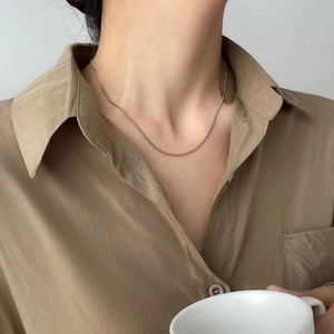 Collier chaîne serpent bicolore or et argent porté par une femme pour un style élégant