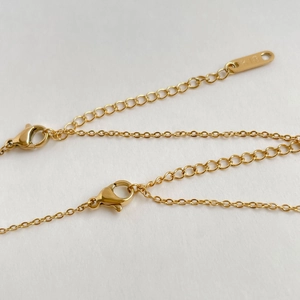 Dettaglio della chiusura a moschettone in oro 18K e incisione del marchio K18 sulla catena