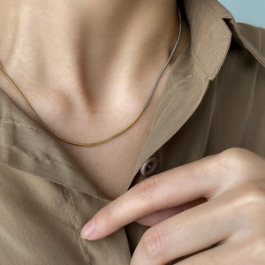 Collier maille serpent minimaliste avec design bicolore or et argent sur un mannequin