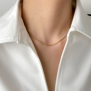 Collier maille serpent minimaliste bicolore or et argent porté par un mannequin femme