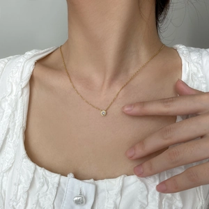 Collana minimalista in oro con ciondolo tondo in zircone verde indossata da modella