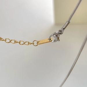 Vue macro du collier bicolore avec gravure K18 sur la plaque et fermoir mousqueton robuste