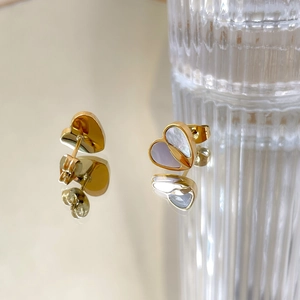 Dettaglio degli orecchini a cuore in oro con inserto in madreperla e chiusura a farfalla