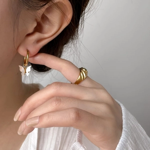 Elegante set di orecchini a farfalla in conchiglia e anello a spirale in oro su una modella