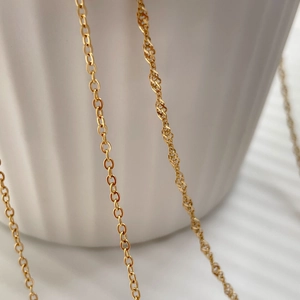Detail of golden O-chain and twisted Singapore water wave chain necklace textures