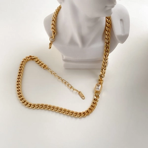 Macro shot of gold Cuban chain necklace with a rectangular zircon and K18 stamp