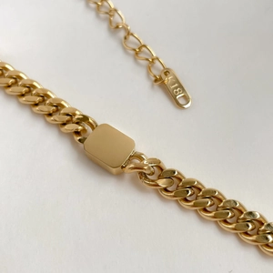 Close-up of golden Cuban chain with K18 engraving detail on the metal jewelry tag
