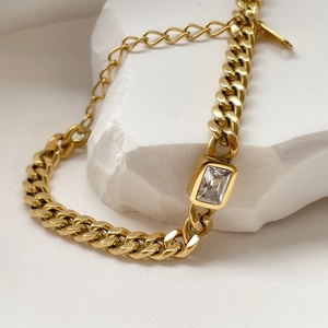Macro shot of gold Cuban chain necklace with a rectangular clear zircon stone pendant