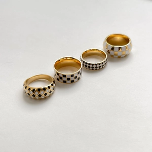 Set of four black and white checkered enamel rings with gold finish in various shapes