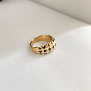 Detailed view of vintage gold ring with black and white checkerboard enamel pattern