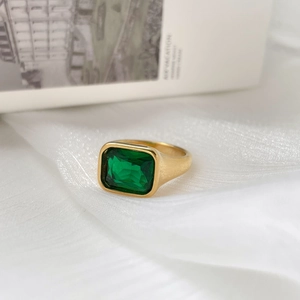 Minimalist gold wide band ring featuring a rectangular emerald green zircon gemstone
