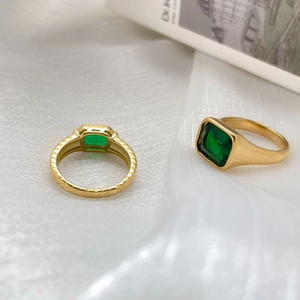 Macro detail of rectangle emerald green gemstone ring with gold vertical stripe design