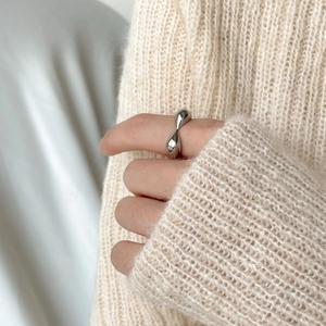 Detail of a chunky 3D heart-shaped silver ring with an organic liquid metal design