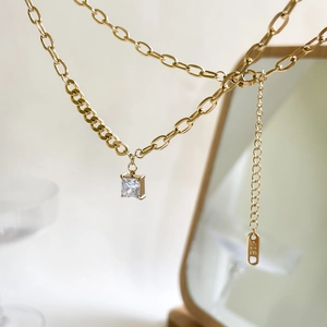 Detail of 18K gold paperclip chain showing the square zircon pendant and 18K hallmark