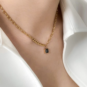 Close-up of square black zircon pendant on a gold mixed-link chain necklace for women