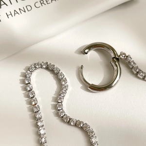 Macro shot of silver sterling hoop earrings with sparkling pavé cubic zirconia chains