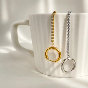 Long tassel drop earrings with sparkling cubic zirconia on a white ceramic mug rim