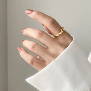 Minimalist gold twisted rope ring featuring a geometric textured design on model's hand