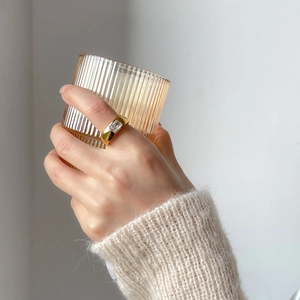 Detail of gold plated matte ring with a square zircon stone worn on a finger