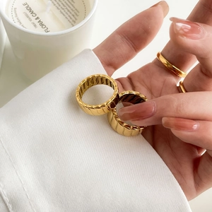 Detail of gold geometric textured rings with textured finish on a lifestyle hand model