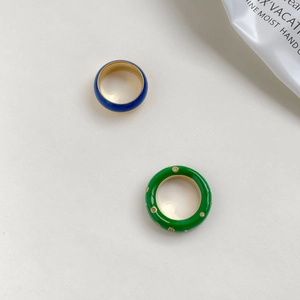 Détails des bagues en émail bleu saphir et vert émeraude serties de zircons étincelants
