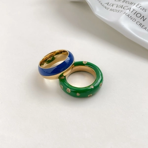 Détail de bagues en émail bleu et vert avec diamants et intérieur en métal doré