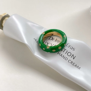 Vue détaillée d'une bague en émail vert avec petits diamants sur fond minimaliste