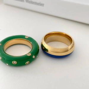 Bagues en émail bleu et vert avec zircon sur fond blanc de style minimaliste