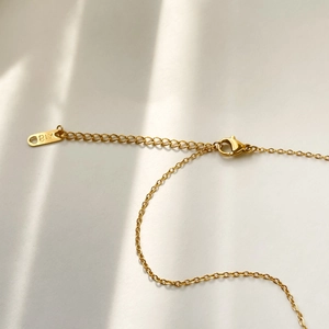 Detailed macro view of 18K gold lobster clasp and extension chain with K18 hallmark