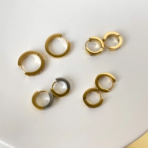 Détails de boucles d'oreilles huggie dorées en C avec zircons et finitions bicolores