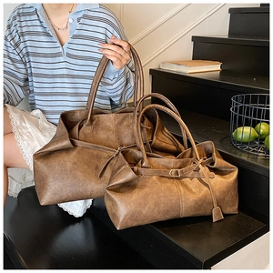 Détail du sac cabas en cuir ciré marron avec texture vintage et boucle décorative