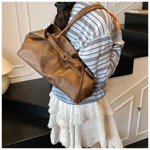 Détail du sac cabas vintage en cuir ciré marron avec boucle en métal doré élégante