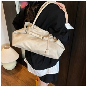 Détail du sac cabas en cuir ciré beige avec fines bandoulières et boucle décorative